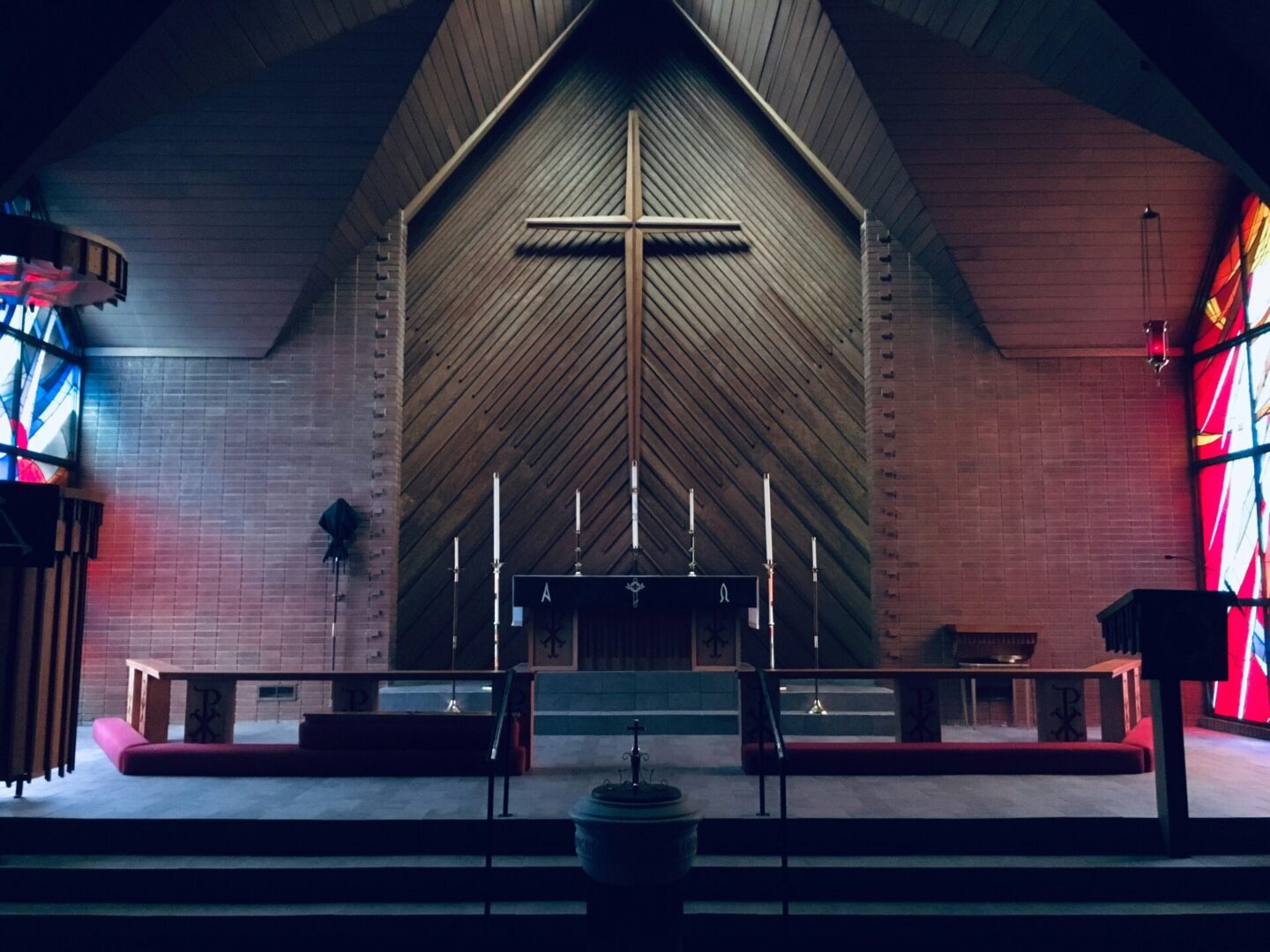 A church with a cross on the wall and a large wooden altar.