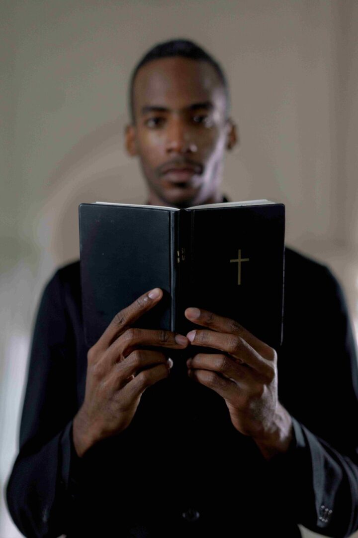 A man holding an open bible in his hands.