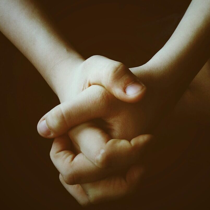 Two hands holding each other in a close up picture.